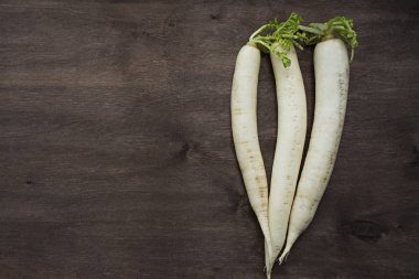 Turp daikon ahşap bir arka plan üzerinde. Metin için yer.