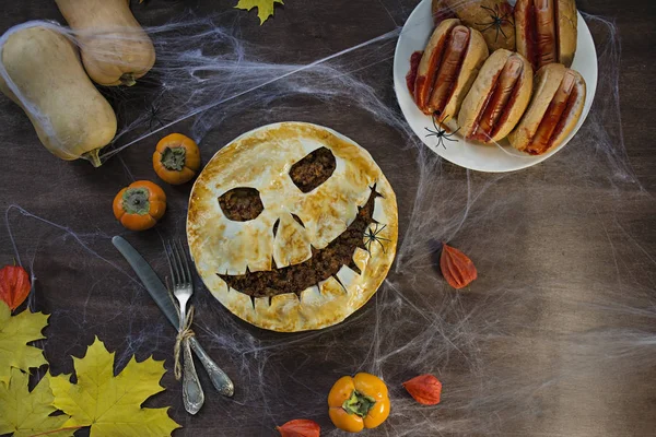 Halloween food. Halloween cake. Halloween homemade cakes. Autumn theme. Halloween homemade dessert idea.Halloween hot dog.Dark wooden background.