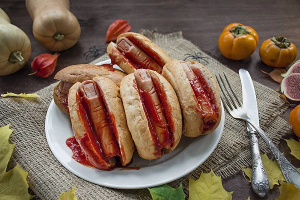 La nourriture d'Halloween. Hot dog d'Halloween. Doigts sanglants de saucisses en rouleaux avec du ketchup. De la nourriture effrayante. De la nourriture à thème. Fond en bois foncé. — Photo