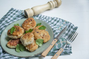 Hafif ahşap arka planda çatallı ve bıçaklı kızarmış köfteler. Düz yat, kapat..