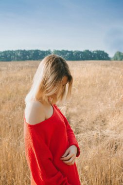 Gün batımında bir tarlada genç bir kadın. Güneşin parıltısı.
