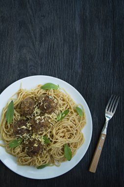 Domates sosu köftesi ve maydanoz ile makarna. Koyu ahşap arka plan. Yukarıdan görüntüle.