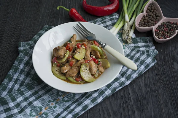 Salada quente com frango, abobrinha e pimenta, polvilhada com sementes de gergelim e ervas. Comida asiática. Fundo de madeira escuro . — Fotografia de Stock