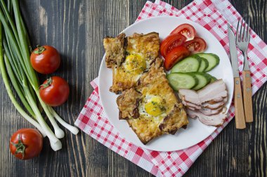 Koyu ahşap arka planda yumurta, sebze ve pastırmalı ızgara sandviç. Nefis bir kahvaltı. Metin için yer.