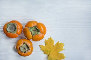 Sarı akçaağaç yaprakları ve hurmalarla sonbahar arkaplanı. Sonbahar konsepti. Mevsimlik tekliflerin planı ve tatil kartları, üst manzara. Metin için boşluk.