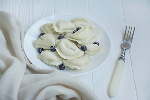 Knödel mit Früchten auf einem weißen Teller. weißer Hintergrund. traditionelles Gericht der Ukraine. — Stockfoto