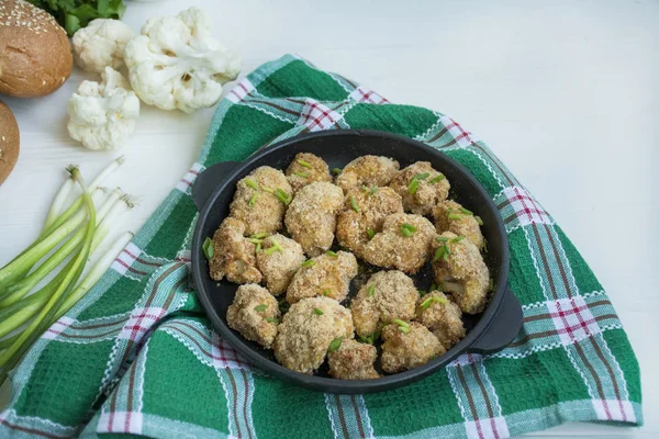 Coliflor empanada frita. Plato en una cacerola pequeña. Fondo de madera blanca . — Foto de Stock