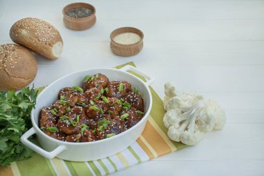 Soslu ve susamlı kızarmış Karnabahar. Asya usulü yemek. Beyaz ahşap arka plan. Metin için boşluk.