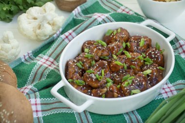 Soslu ve susamlı kızarmış Karnabahar. Asya usulü yemek. Beyaz tahta arkaplan.