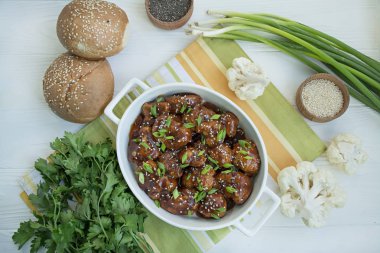 Soslu ve susamlı kızarmış Karnabahar. Asya usulü yemek. Beyaz ahşap arka plan. Mesaj için yer var. Düz yatıyordu.