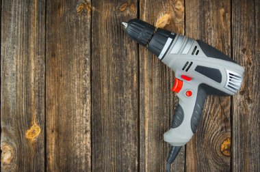 Tahta bir masada elektrikli matkap. Boşluğu kopyala.