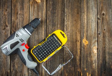 Tahta bir masa üzerinde çalışmak için enjektörlü elektrikli matkap. Boşluğu kopyala.