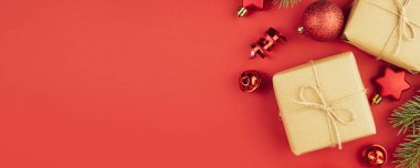 Hediye kutularından, kırmızı toplardan, kırmızı arka planda yılan balığından Noel arkaplanı. Noel süslemeleri. Noel arkaplanı. Banner planı, kartpostal. Daire yalan söylüyordu. Boşluğu kopyala