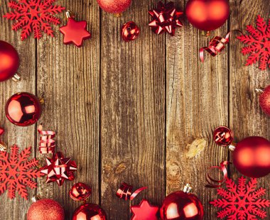 Noel kompozisyonu. Noel kırmızı oyuncaklarından çerçeve, ahşap arka planda hediyeler. Düz konum, üst görünüm, kopyalama alanı.