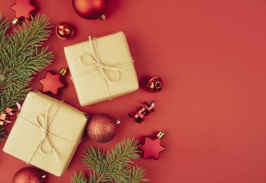 Hediye kutularından, kırmızı toplardan, kırmızı arka planda yılan balığından Noel arkaplanı. Noel süslemeleri. Noel arkaplanı. Banner planı, kartpostal. Daire yalan söylüyordu. Boşluğu kopyala