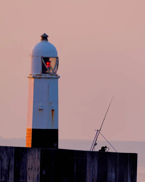 Angelrute und Leuchtturm im Morgengrauen — Stockfoto