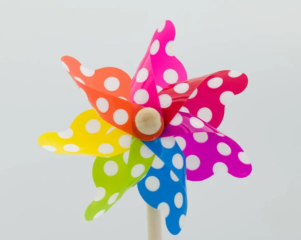 A white spotted  toy windmill.