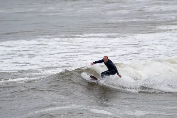 Male surfing in light rain — Stock Photo, Image