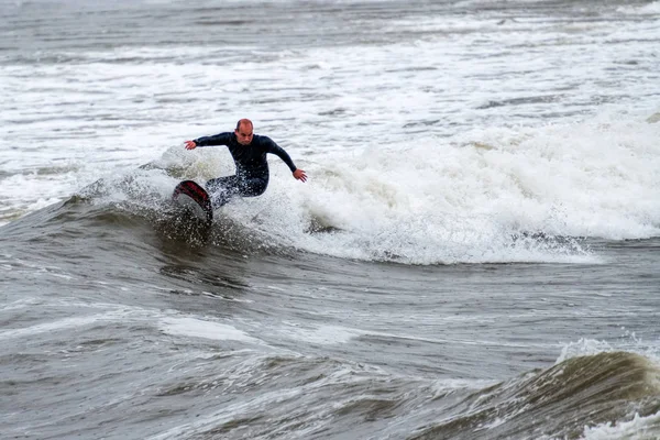 Middle-aged surfer rides the waves — Stock Photo, Image