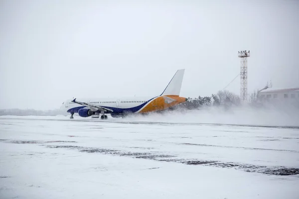 在暴风雪期间 现代双引擎客机在机场滑行 — 图库照片