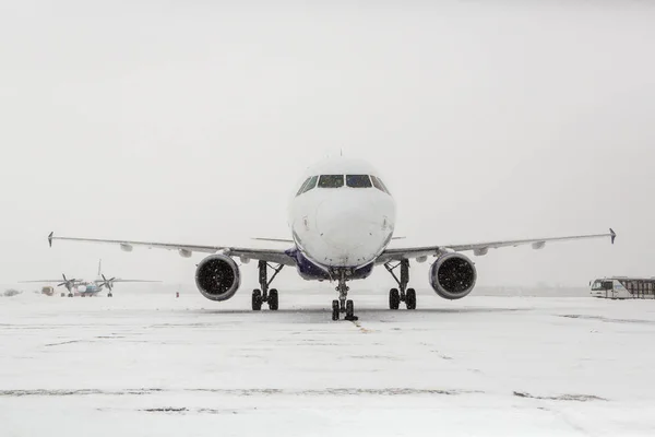 在暴风雪期间 现代双引擎客机在机场滑行 — 图库照片