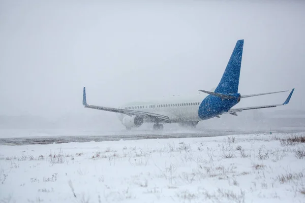 在暴风雪期间 现代双引擎客机在机场滑行 — 图库照片