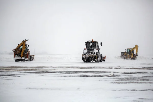 Clearing airport with bulldozers at airport aprons from snow during snow storm