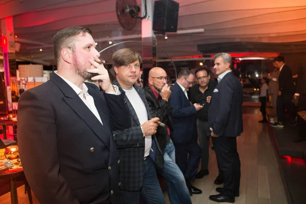 オデッサ ウクライナ 2017 エレガントな服を着て男性の夜のパーティーの中に豪華なナイトクラブで葉巻を吸って — ストック写真