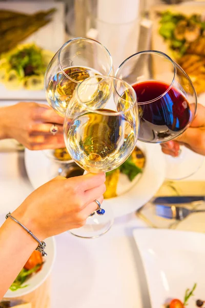 Close up of people toasting with wine glasses