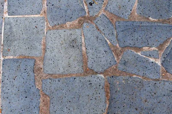 Taş levhaların kaldırımı. gri taş yüzey volkanik kaya serpiştirilmiş