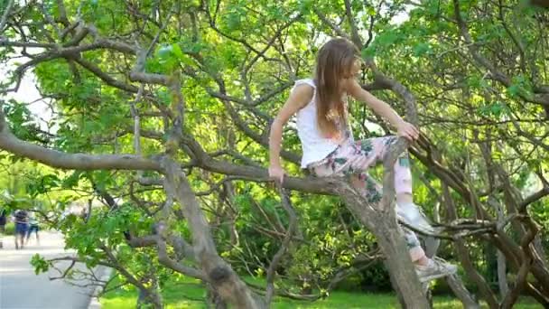 Schattig meisje in bloeiende apple tree tuin genieten van de warme dag — Stockvideo