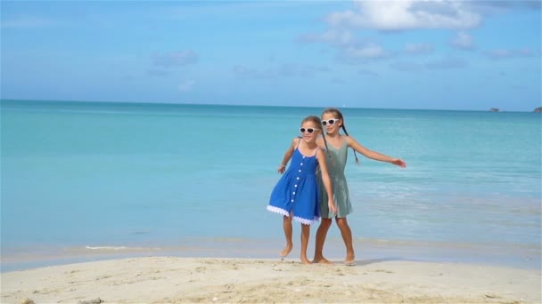 Kleine fröhliche lustige Mädchen haben viel Spaß am tropischen Strand, wo sie zusammen spielen. Zeitlupe — Stockvideo