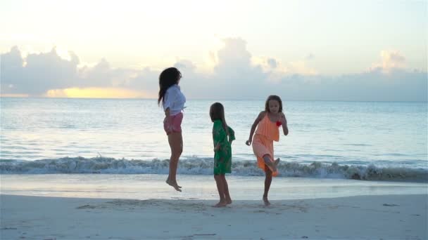 Sevimli küçük kızlar ve beyaz sahilde genç bir anne. — Stok video