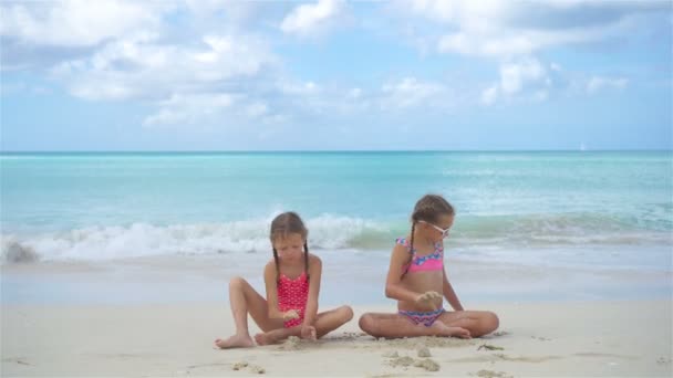 Rozkošné holčičky hrající si s pískem na pláži.