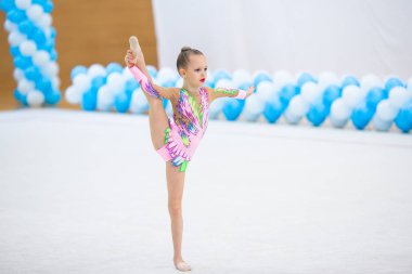 Halıda performansı olan küçük, güzel, aktif bir jimnastikçi kız.