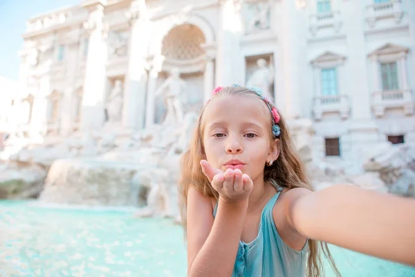 Adorável menina tirando selfie pela Fonte de Trevi em Roma . — Fotografia de Stock