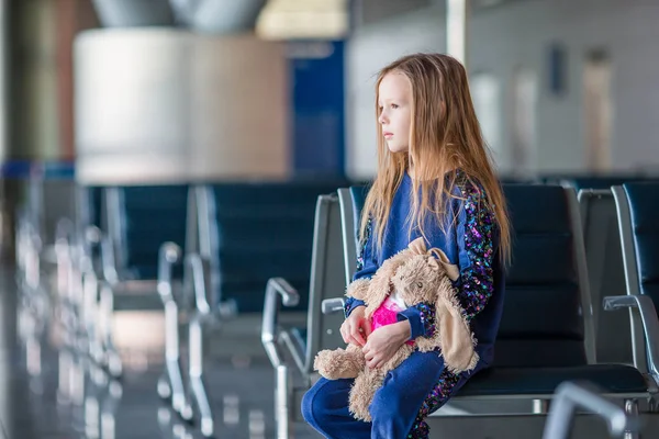 Adorable niña con equipaje en el aeropuerto esperando el embarque —  Fotos de Stock