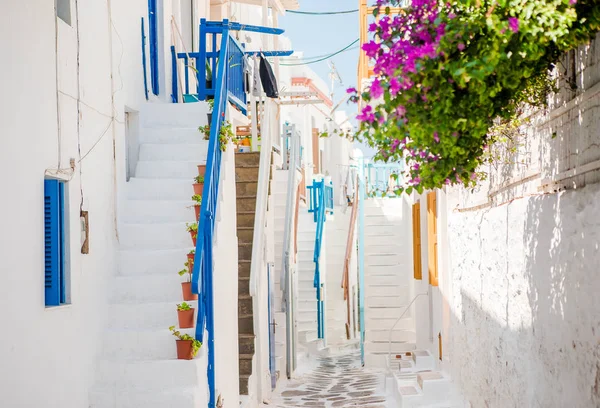Úzké ulice ostrova s modrými balkony, schody a květinami. — Stock fotografie