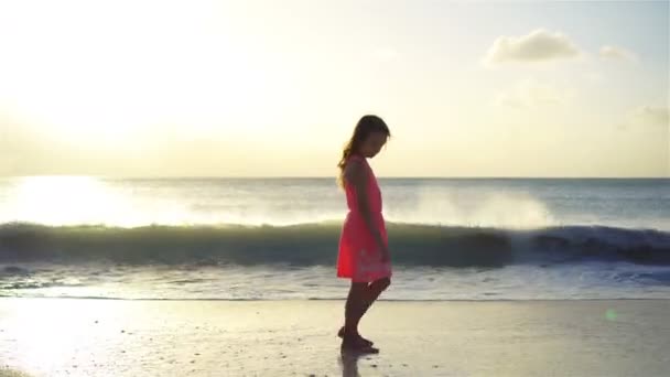 Söt glad liten flicka på vit strand vid solnedgången. — Stockvideo