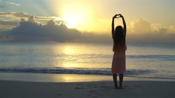 Schattig gelukkig klein meisje op wit strand bij zonsondergang. — Stockvideo
