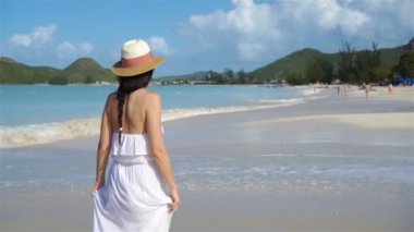 Genç ve güzel bir kadın beyaz kumsalda.