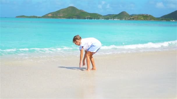 Hermosa niña en vestido en la playa divirtiéndose . — Vídeo de stock