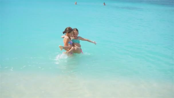 小さな幸せな女の子はね。ターコイズ ブルーの海を泳ぐ準備ができて実行している子供 — ストック動画