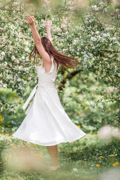 Schöne Frau genießt Duft im Frühlingskirschgarten — Stockfoto