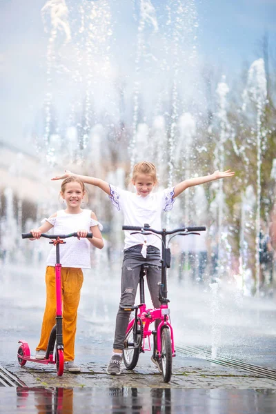 Kleine meisjes plezier in buiten fontein op warme dag — Stockfoto