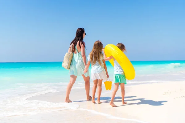 Sevimli küçük kızlar ve beyaz sahilde genç bir anne.. — Stok fotoğraf
