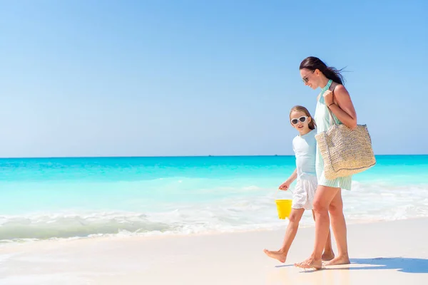 热带海滩上可爱的小女孩和年轻的母亲 — 图库照片