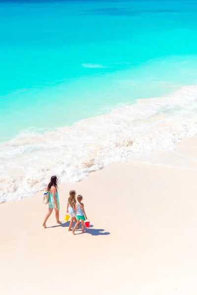 Entzückende kleine Mädchen und junge Mutter am weißen Strand. — Stockfoto