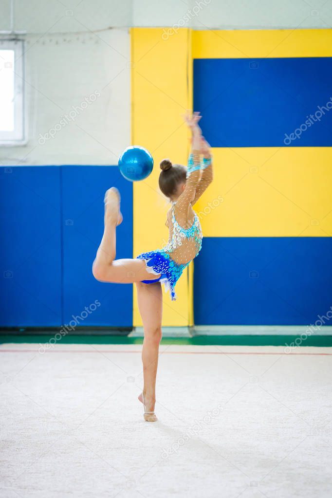 Beautiful little active gymnast girl with her performance on the carpet