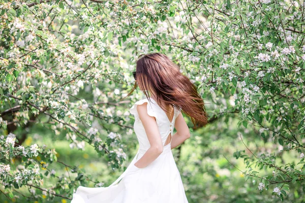 Hermosa mujer disfrutando del olor en el jardín de cerezas de primavera —  Fotos de Stock